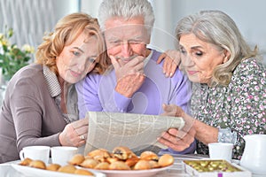 Elderly people having breakfast and reading a newspaper