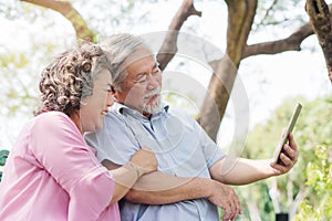 Elderly people lifestyles and communication technology. Happy grandparent using tablet video call and talking with family. photo