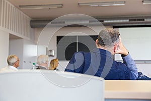 Elderly people are sitting in a classroom photo