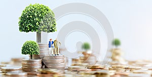 Elderly people sitting on coins stack.