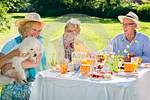 Elderly people sitting with pet at picnic table