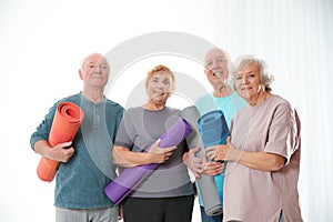 Elderly people with yoga mats
