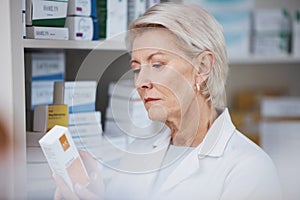 Elderly pharmacist, medicine reading and stock in a healthcare, wellness and pharmaceutical store. Pharmacy inventory