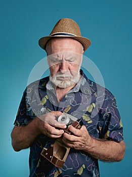 An elderly photographer adjusts his camera