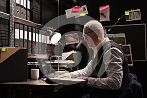 Elderly police officer analyzing confidential federal files