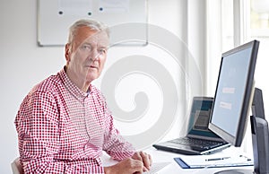 Elderly professional man using his computer in the office