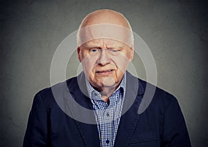 Elderly sad skeptical man looking down