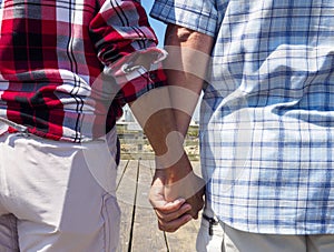 Elderly senior couple holding hands on a walk on a summer day