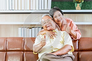 Elderly senior couple hugging each other with thumb up gesture for happy retirement lifestyle