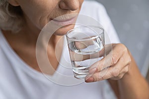 Elderly senior granny drinking fresh pure water.