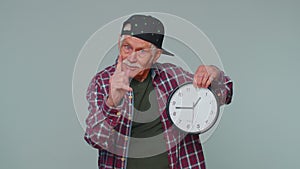 Elderly senior man showing time on clock watch, ok, thumb up, approve, pointing finger at camera