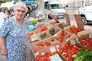 Elderly senior woman buying fresh vegetables and fruits in farmer`s market