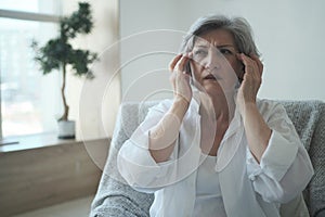 Elderly senior woman suffering from migraines and headaches, memory lapses and sleep difficulties.