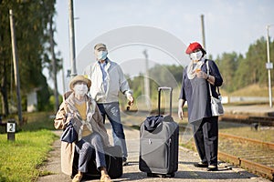 elderly seniors people with face masks waiting train before traveling during a pandemic