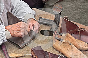 Elderly shoemaker makes artisan shoes