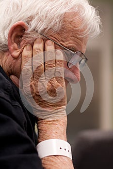 Elderly sick hospital patient wearing wristband