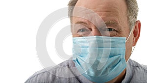 Elderly smiling man in a blue medical mask during corona quarantine