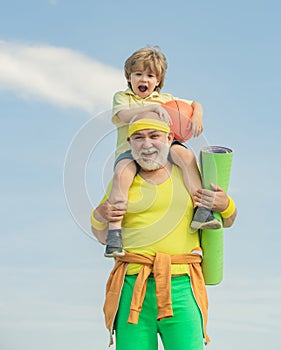 Elderly sporty man and young boy sporting morning workout - copy space. Healthy family lifestyle. Sport yoga and fitness