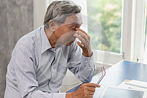 Elderly stress tired and holding his nose suffer sinus pain fatigue