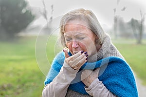 Elderly stylish woman coughing or sneezing