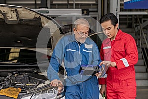 Elderly vehicle mechanic use an obd2 car diagnostics device scanner to interpreting automotive error codes