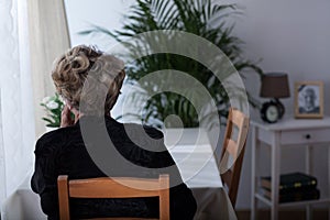 Elderly widow sitting alone photo