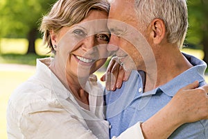 Elderly wife and husband cuddling outdoors