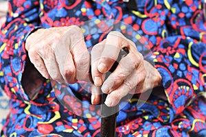 Elderly woman of 90 years put her hands on a cane, retirement and disability, close up.Elderly people are susceptible to the virus