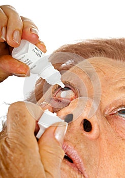 Elderly woman applying eye drops