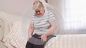 Elderly woman on bed with leg pain