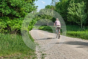 Elderly woman biking in the Perlacher Forst