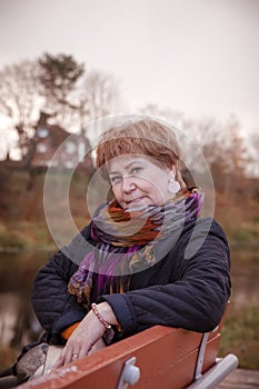 Elderly woman in   black jacket and   colored scarf