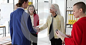Elderly woman boss encourage and thank happy employee for good work and shake hand