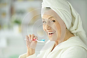 Elderly woman brushing her teeth