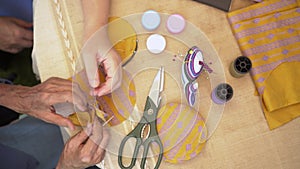 Elderly woman with caregiver in the needle crafts occupational therapy