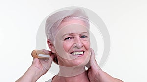 Elderly Woman Caring for Hair with a Comb on White Background