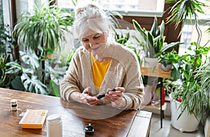 Elderly woman checking her blood sugar level