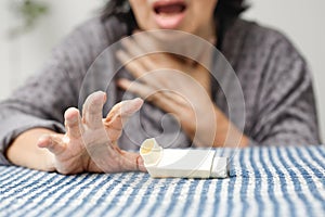 Elderly woman choking and holding an asthma spray