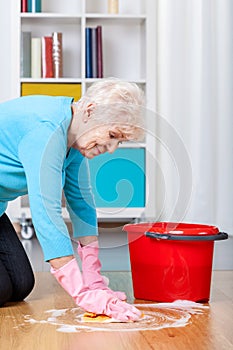 Elderly woman cleaning floor