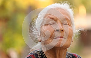 The elderly woman with closed eyes photo