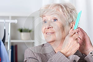Elderly woman combing hair