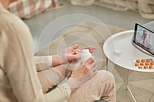 An elderly woman communicates remotely via a tablet with her doctor and takes medications according to his