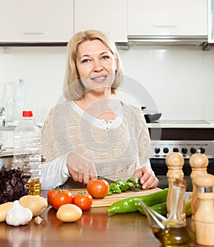 Elderly woman cooking lunch with veggy