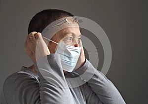 An elderly woman, during the coronavirus pandemic, wears a protective medical mask. Flu epidemic, dust allergy, protection from