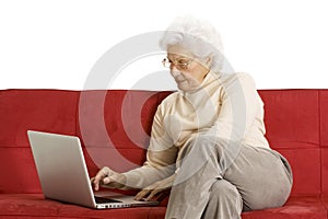 Elderly woman on the couch with laptop