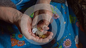 An elderly woman counts the coins