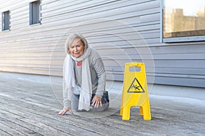 Elderly woman crawling on her knees after slipping