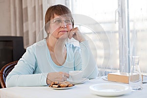 Elderly woman with a cup of coffee