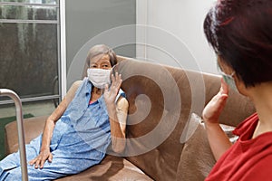 Elderly woman and daughter keeping distance to prevent covid-19