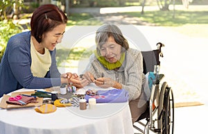 Elderly woman and daughter in the needle crafts occupational therapy for Alzheimerâ€™s or dementia